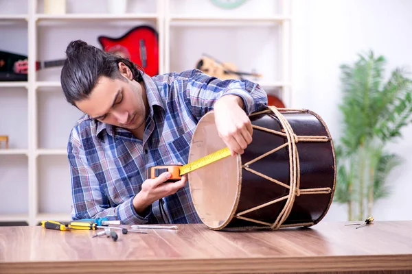 Jovem reparador bonito reparação tambor — Fotografia de Stock