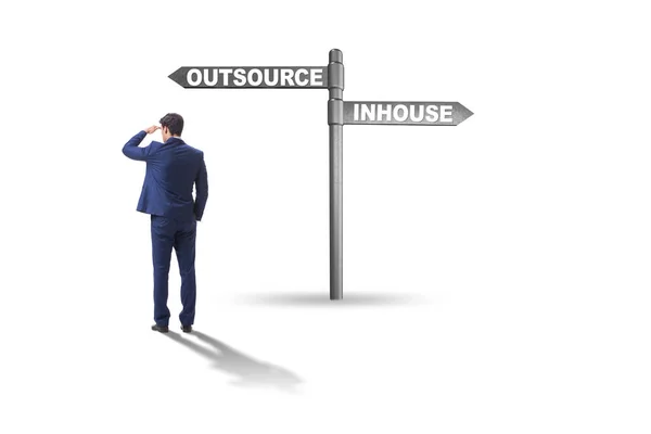 Businessman at crossroads deciding between outsourcing and inhou — Stock Photo, Image