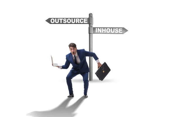 Businessman at crossroads deciding between outsourcing and inhou — Stock Photo, Image