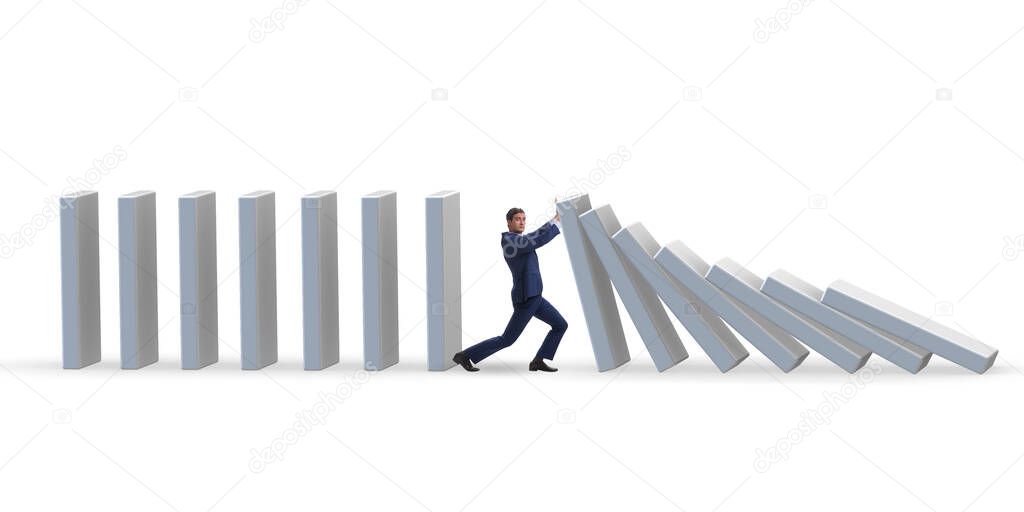Businessman preventing domino effect in business concept