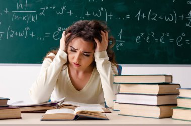 Karatahtanın önünde genç bayan matematik öğretmeni.