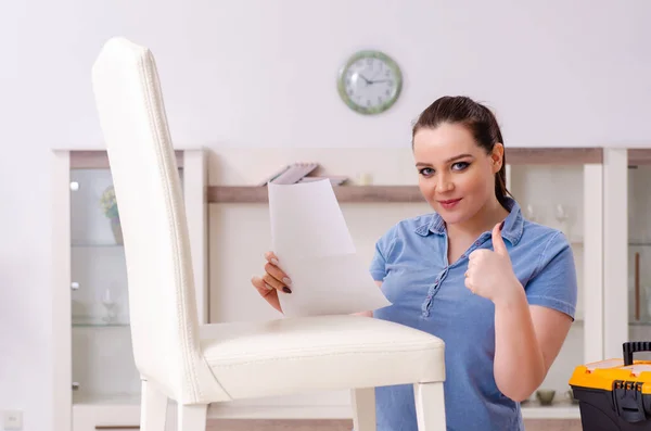 Jonge vrouw repareert stoel thuis — Stockfoto