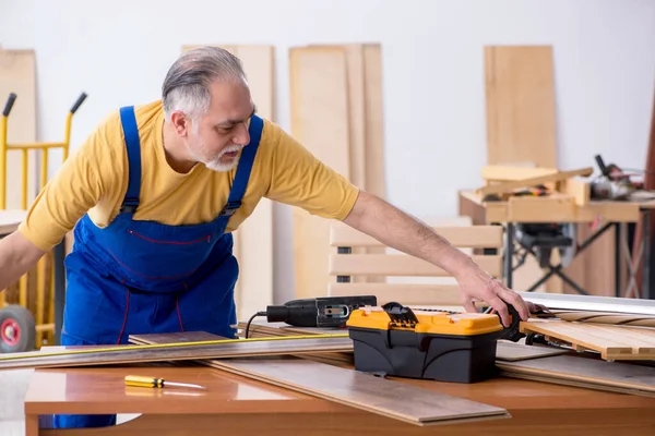 Oude mannelijke timmerman aan het werk in werkplaats — Stockfoto