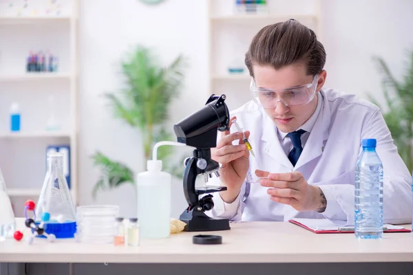 Młody chemik eksperymentujący w laboratorium — Zdjęcie stockowe