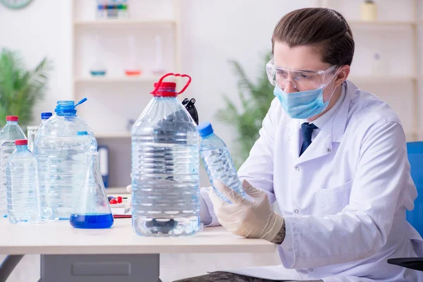 Młody chemik eksperymentujący w laboratorium — Zdjęcie stockowe