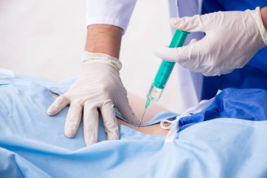 Kadın hasta klinikte iğne oluyor.