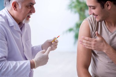 Erkek hasta aşı aşısı için doktoru ziyaret ediyor.