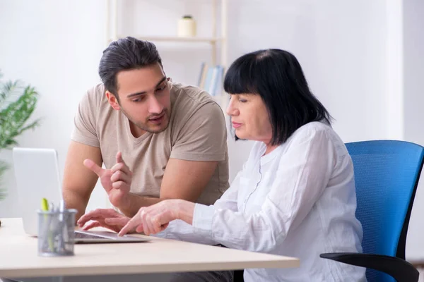 Ung, mannlig ansatt som forklarer oss hvordan – stockfoto