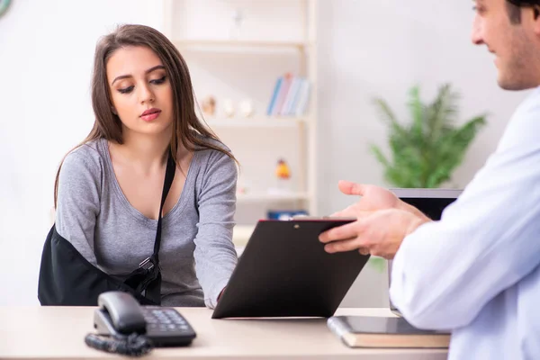 Ung manlig läkare och kvinnlig vacker patient — Stockfoto