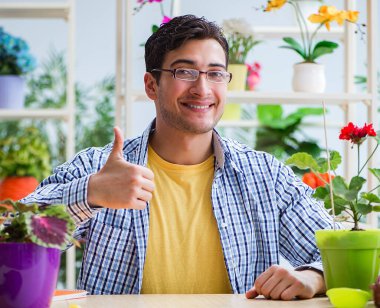 Çiçekçide çalışan genç bir adam.