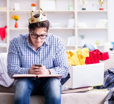 Genç adam dağınık bir odada çalışıyor.