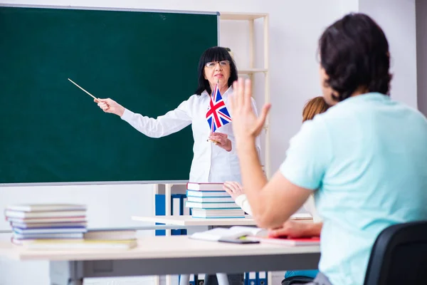 Old female english teacher and students in the classroom — Stock Photo, Image