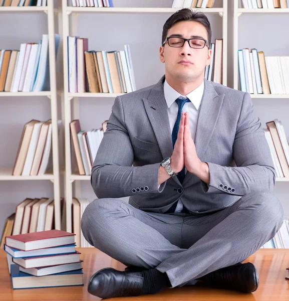 Estudiante de negocios en posición de loto concentrándose en la libr — Foto de Stock