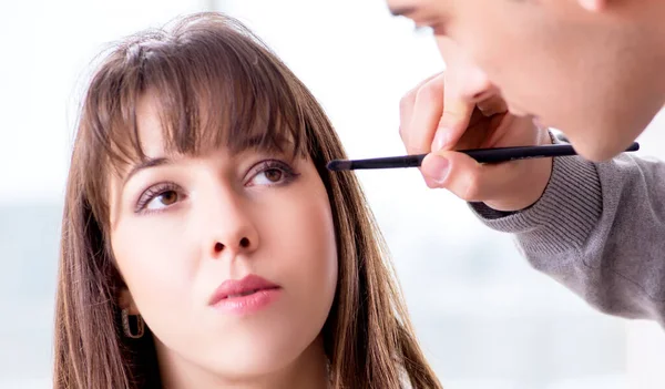 Mann macht Make-up für süße Frau im Schönheitssalon — Stockfoto