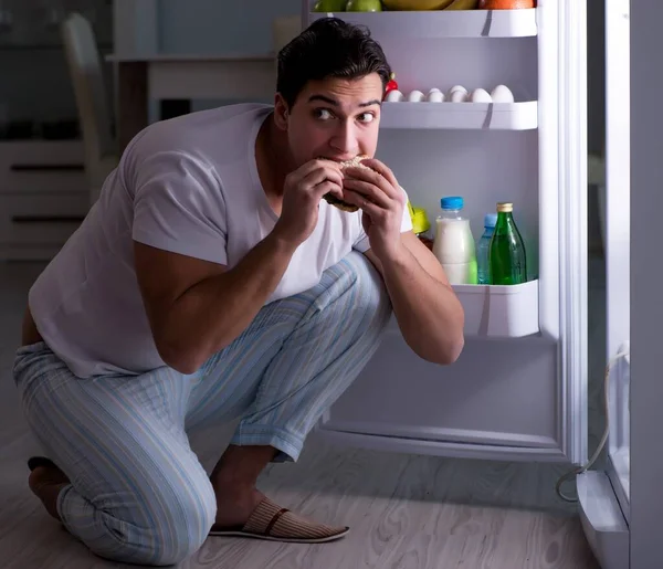 Mann am Kühlschrank isst nachts — Stockfoto