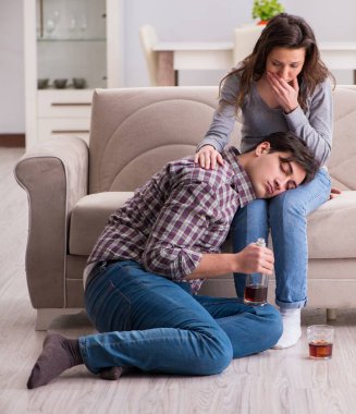 Genç bir aile kavramında içki sorunu yaşayan sarhoş bir koca.