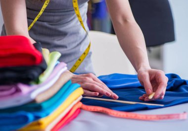 Kadın terzi dikiş dikmek için dikiş dikiyor.