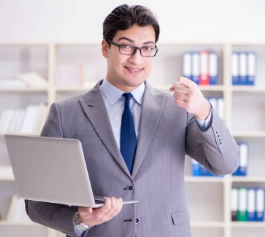 Ofisteki iş adamı dizüstü bilgisayarla çalışıyor.