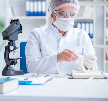 Bir laboratuarda deney yapan kadın bir bilim adamı.