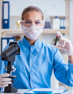 Bir laboratuarda deney yapan kadın bir bilim adamı.