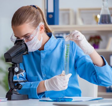 Bir laboratuarda deney yapan kadın bir bilim adamı.