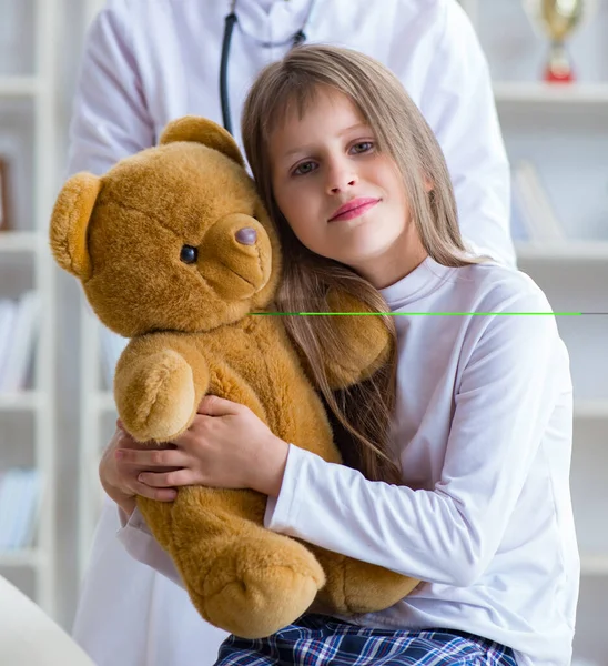 Vrouw vrouwelijke arts onderzoeken klein schattig meisje met speelgoed beer — Stockfoto