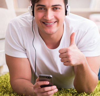 Evde müzik dinleyen genç bir öğrenci.