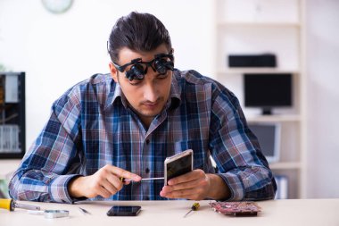 Genç yakışıklı teknisyen cep telefonu tamir