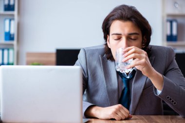 Hasta erkek çalışan ofiste acı çekiyor.