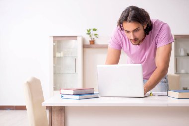 Evde sınava hazırlanan genç bir erkek öğrenci.