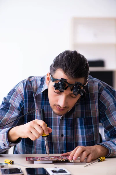 Young handsome technician repairing mobile phone — Stock Photo, Image