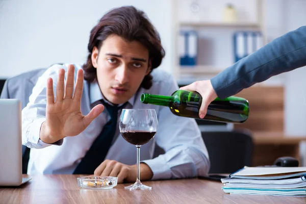 Empregado do sexo masculino que bebe álcool e fuma cigarros no trabalho — Fotografia de Stock