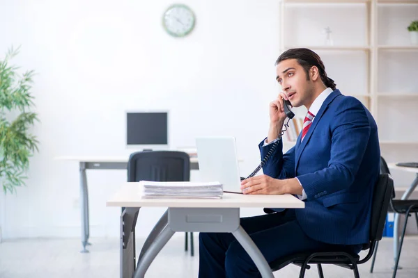 Νεαρός άνδρας επιχειρηματίας κάθεται στο γραφείο — Φωτογραφία Αρχείου