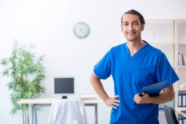 Klinikte çalışan genç erkek doktor.