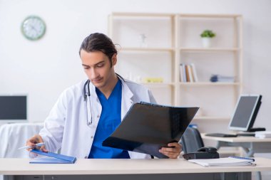 Klinikte çalışan genç erkek doktor.