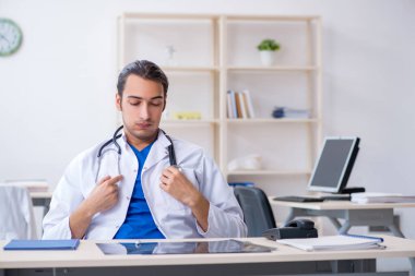 Klinikte çalışan genç erkek doktor.