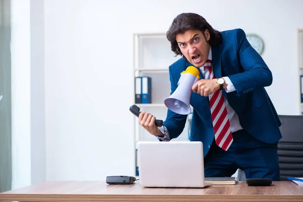 Jonge mannelijke zakenman werkzaam in het kantoor — Stockfoto