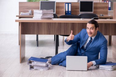 Genç bir erkek işçi ve ofiste çok fazla iş var.