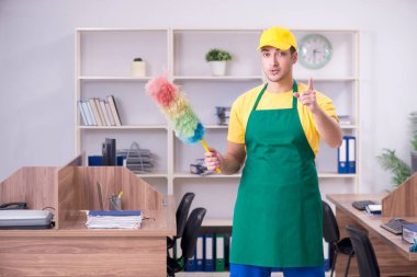 Genç müteahhit ofisi temizliyor.