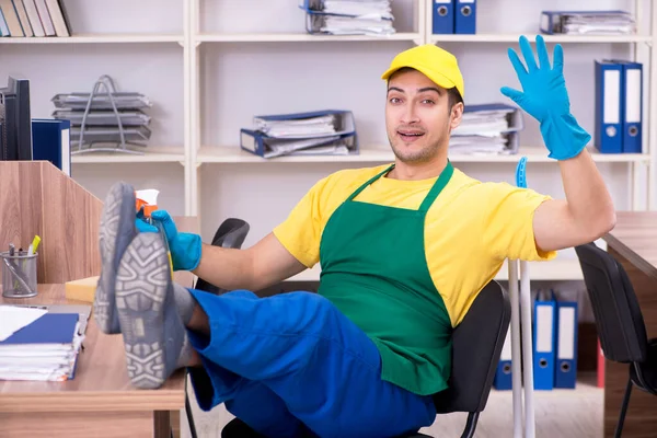 Joven contratista masculino limpiando la oficina —  Fotos de Stock