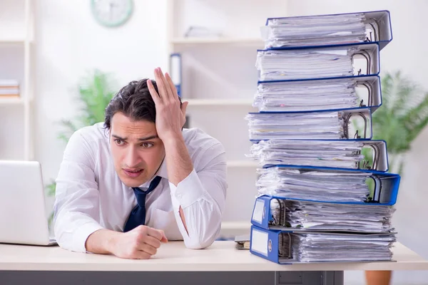 Joven empleado masculino infeliz con el trabajo excesivo — Foto de Stock