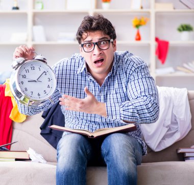 Genç adam dağınık bir odada çalışıyor.