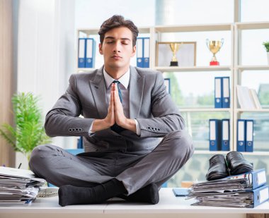 Ofiste masanın üstünde oturan bir iş adamı.