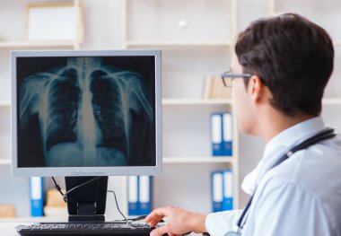 Doktor radyoloji uzmanı röntgen görüntülerine bakıyor.