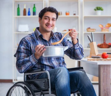 Engelli adam mutfakta çorba hazırlıyor.