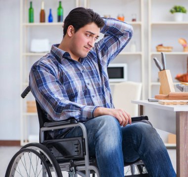 Engelli genç koca mutfakta çalışıyor.