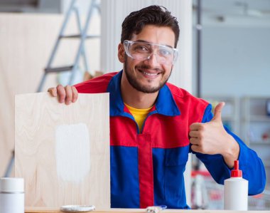 Yooung marangoz boyayla uğraşıyor.