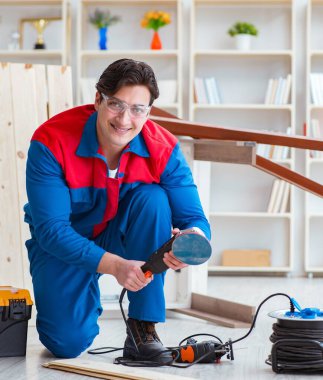 Genç marangoz ahşap kalaslarla çalışıyor.