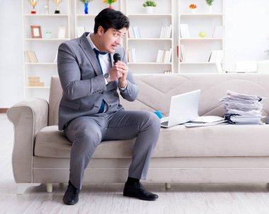 Üzgün işadamı ofiste şarkı söylüyor.