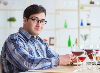 Profesyonel şarap garsonu kırmızı şarap tadıyor.